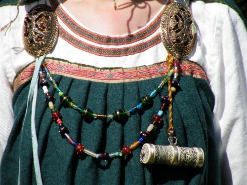 Detalle de la vestimenta de una vikinga; podemos observar los detalles, los objetos, y las cadenas.